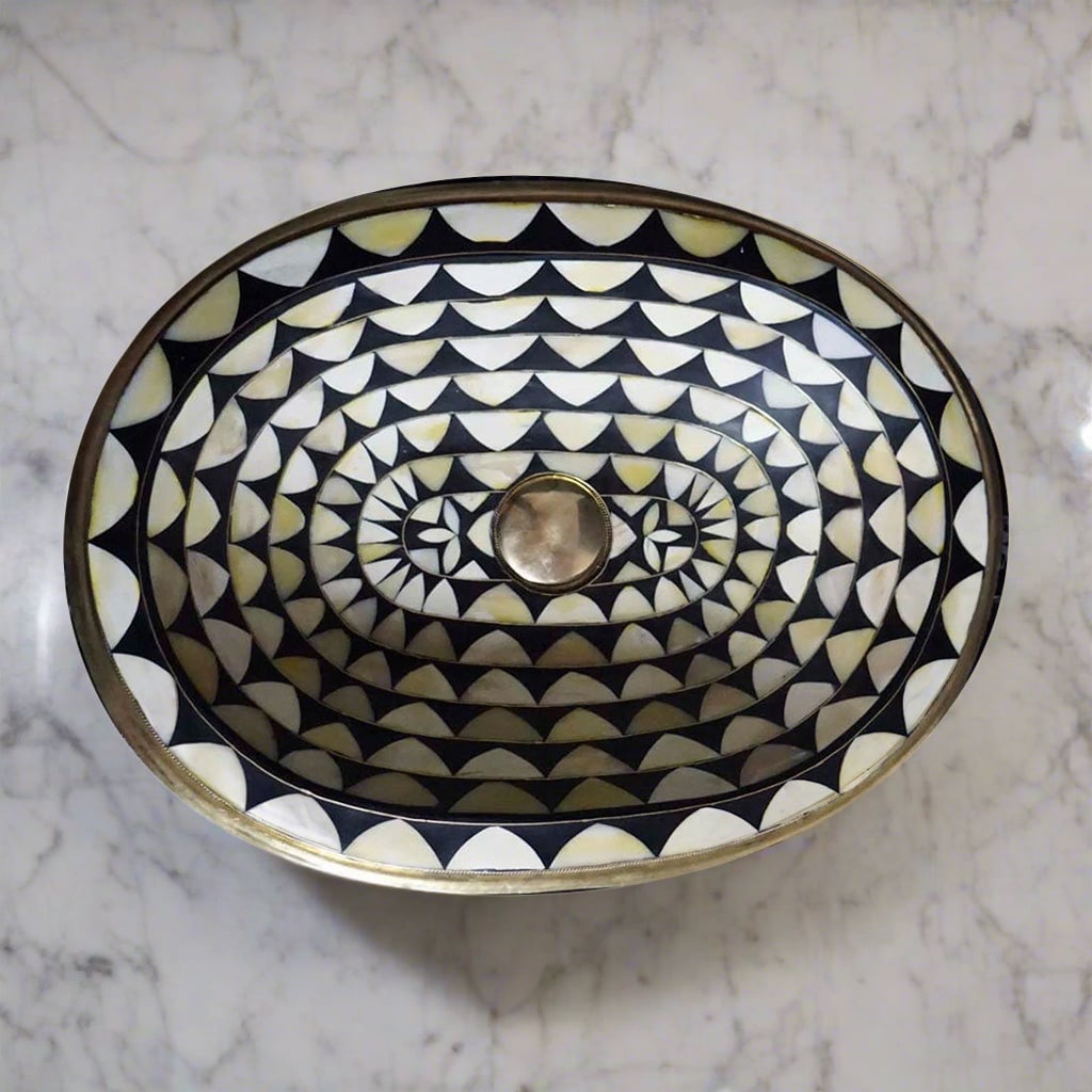 Oval Undermount Brass Sink decorated with handmade pattern over a counter top with white marbel 