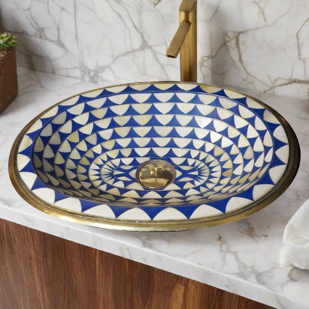 Oval Undermount Brass Sink decorated with handmade pattern over a counter top with white marbel 