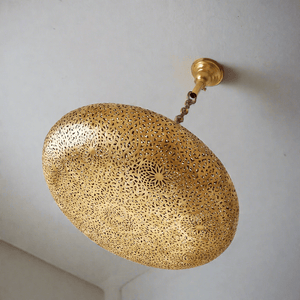 Moroccan brass lampshade fixture hanging from a white ceiling 