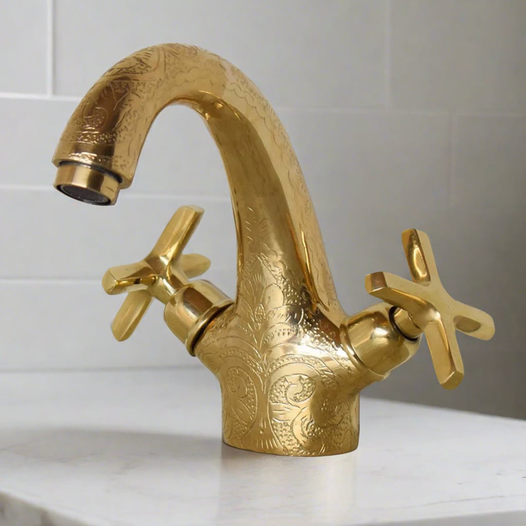 Unlacquered Brass Faucet engraved with dual handles over a countertop of a modern bathroom 