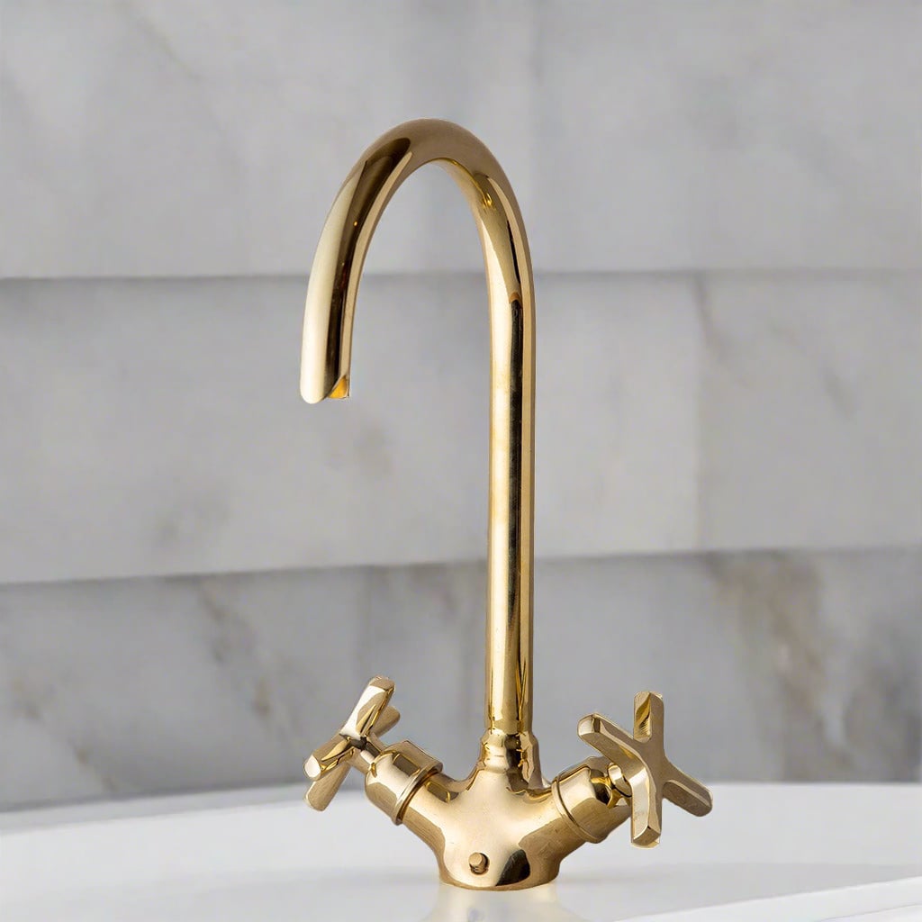  A brass faucet with double tap mixer over a countertop with marble background 