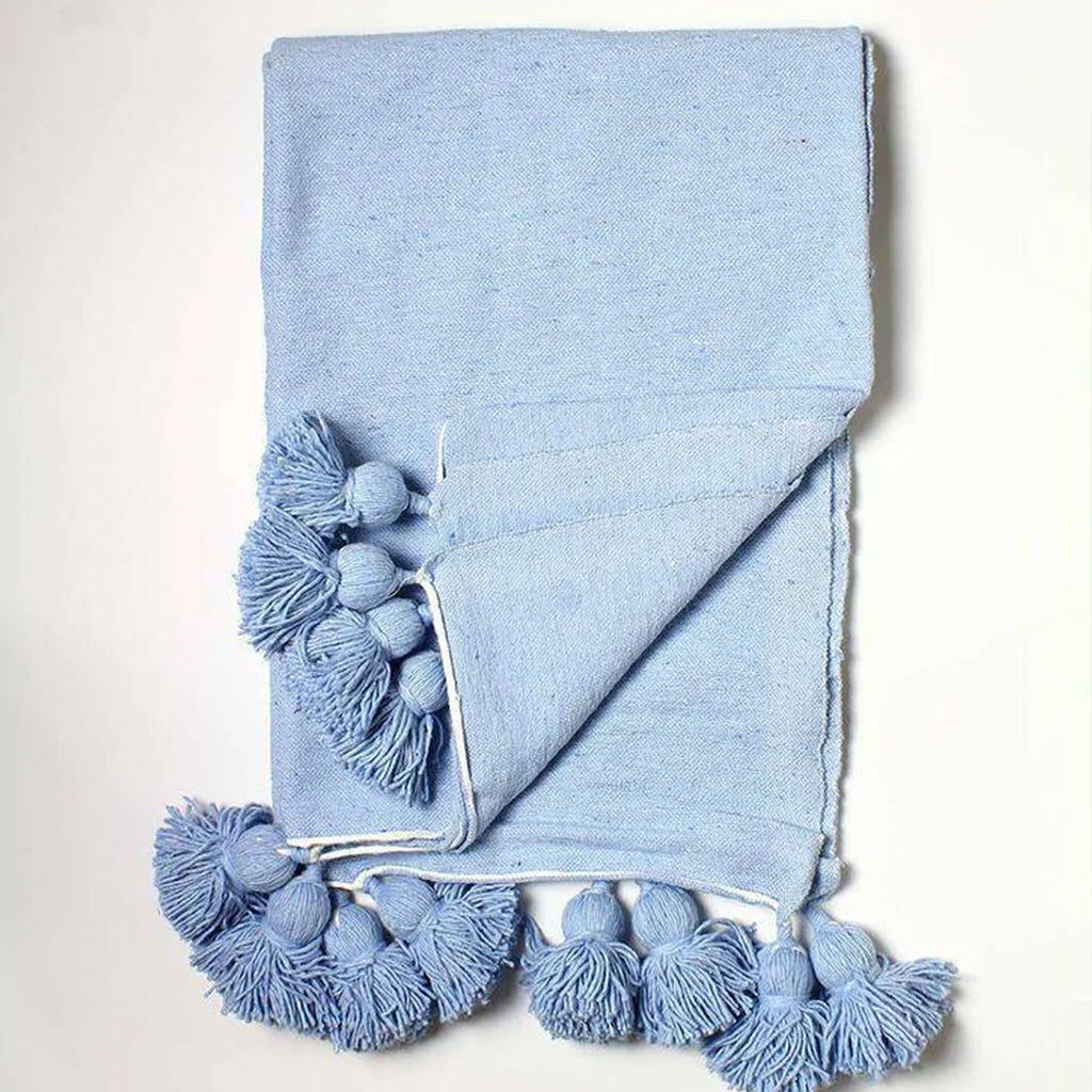 Moroccan Pompom Blanket in light blue against a white background - Moroccan Interior