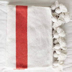 Moroccan Pompom Blanket in white and orange against a white background - Moroccan Interior