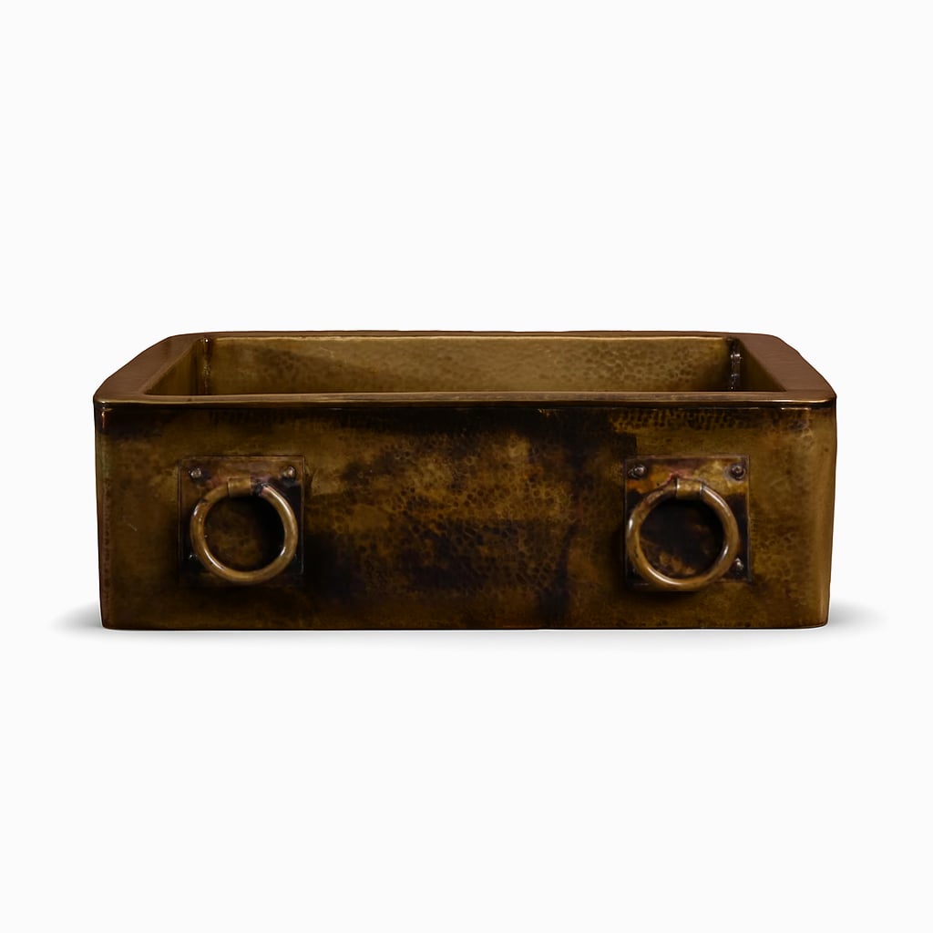 Rectangular antique copper farmhouse sink featuring a hammered finish and two brass ring handles on the front apron, displayed on a white background