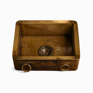 Rectangular antique copper kitchen sink with hammered finish and dual ring handles on a white background