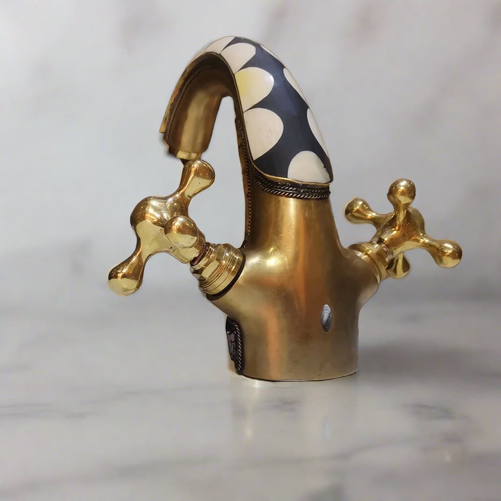 Back view of a Brass Bathroom Faucet with dual handles standing on a countertop with a marbel background - Moroccan Interior