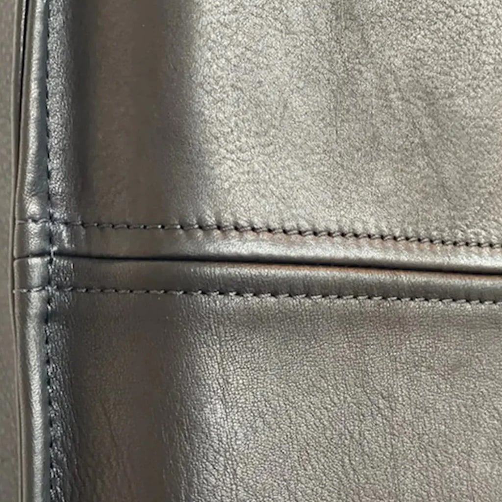 Detailed view of stitched black leather panels on a headboard