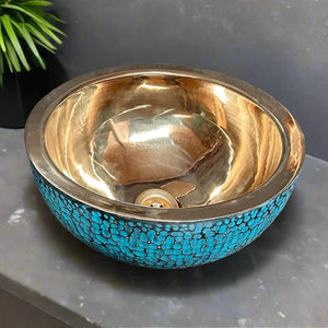 Artistic brass vessel sink with turquoise blue hammered detailing and glossy golden inner finish, placed on a dark counter