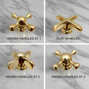 Four brass faucet handle designs displayed on a marble background, including Knobs Handles ST 1, Flat Handles, Knobs Handles ST 2, and Knobs Handles ST 3, each with unique shapes and finishes