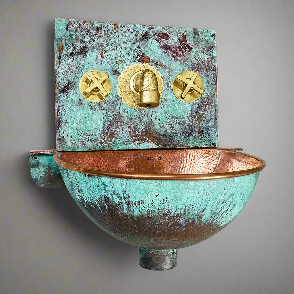 Hand-hammered copper wall-hung sink with verdigris patina and polished brass faucet, combining artisanal craftsmanship with timeless elegance
