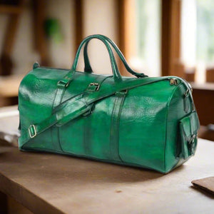 A three-quarter view of a handcrafted green leather travel bag with an adjustable strap, spacious interior, and a side pocket for convenience