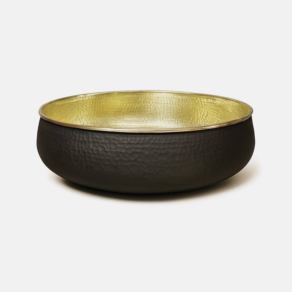 Side view of a hammered brass sink with matte black outer finish and reflective gold interior