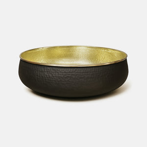 Side view of a hammered brass sink with matte black outer finish and reflective gold interior
