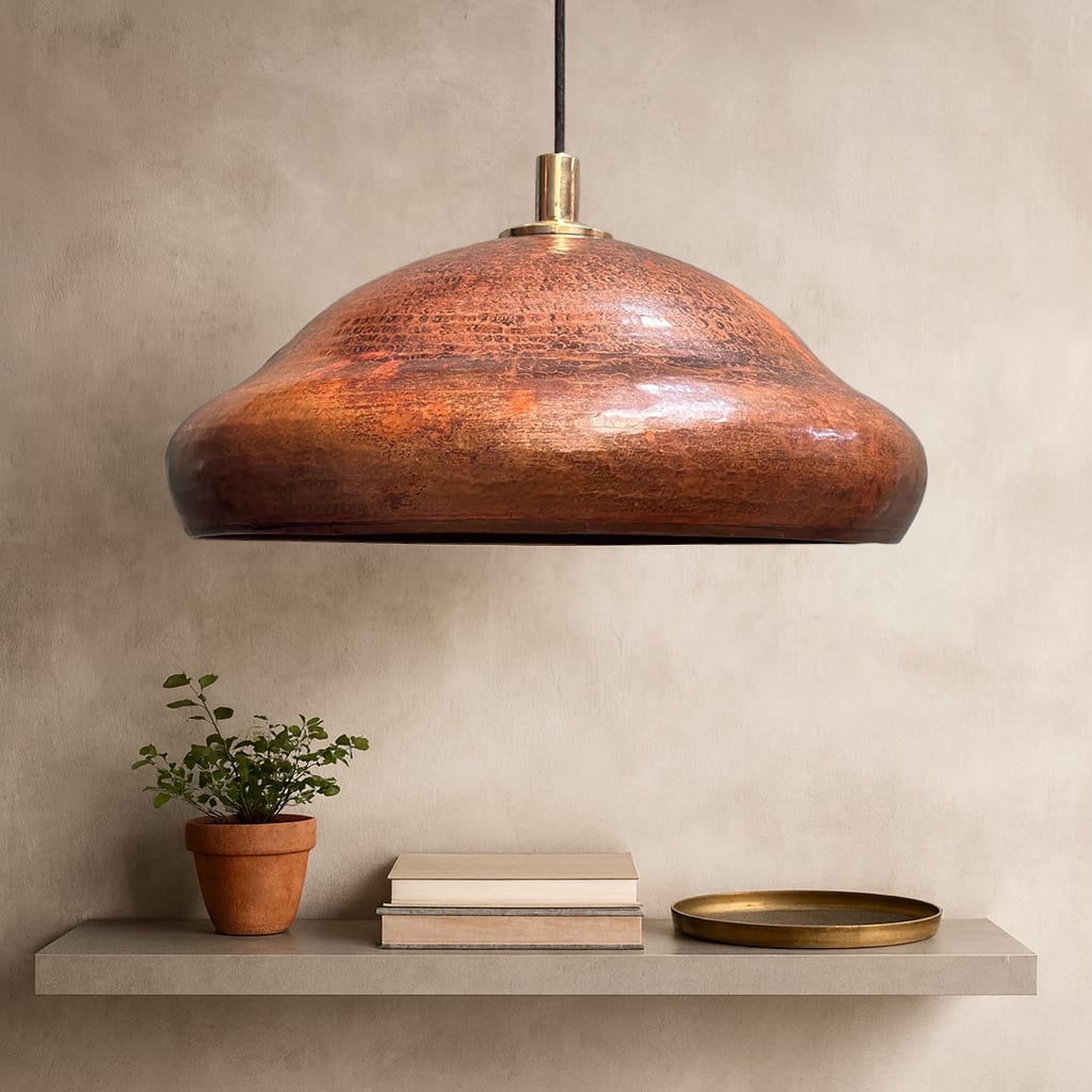 Handcrafted Moroccan copper pendant light with brass fixture, shown unlit, revealing its rich natural patina and smooth curves