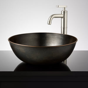 Black hammered copper vessel sink installed on a glossy black countertop with a modern brushed nickel faucet in the background