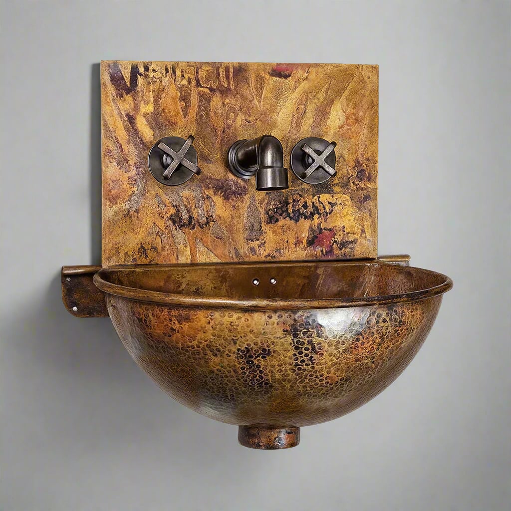 Wall-hung hammered copper sink with a golden-brown patina finish, featuring a rounded bowl and matching copper backplate with cross-handle taps