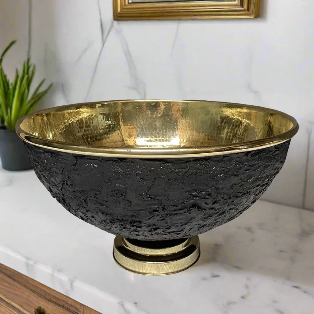  Elegant round brass vessel sink with hammered gold interior and textured black exterior on a marble countertop