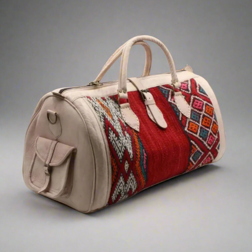 A handcrafted Moroccan travel bag featuring premium ivory leather and vibrant kilim accents in red and multicolored geometric patterns