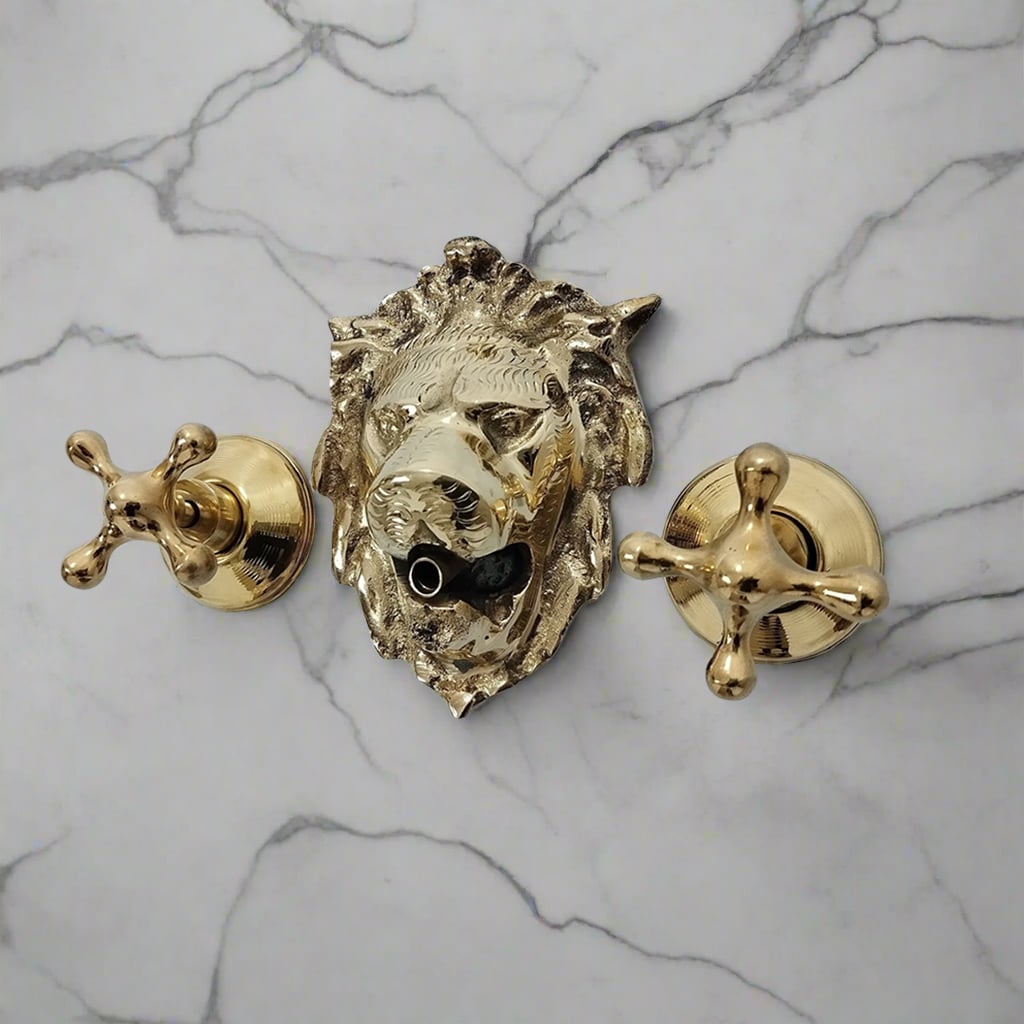 Brass lion head wall-mounted faucet with two cross handles on a light marble background