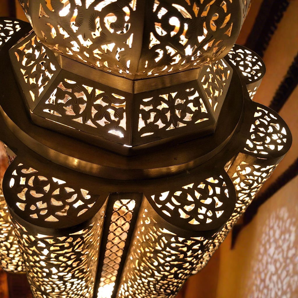 Close-up of a Moroccan ceiling fixture showcasing detailed brass craftsmanship and elaborate patterns, highlighting the artisanal quality