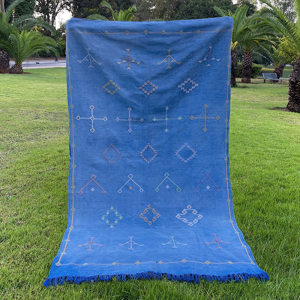 Handwoven Moroccan sabra cactus silk rug in rich royal blue, featuring traditional Berber embroidered motifs and finished with blue fringed edges