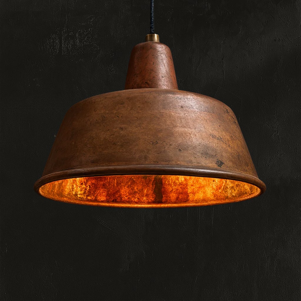 Handcrafted Moroccan pendant light with a wide, flared hammered copper shade, featuring a rustic patina and warm glowing interior, set against a dark background