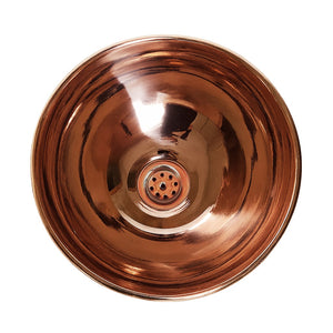 Polished round copper basin with a smooth reflective finish and central drain, showcasing elegant craftsmanship and timeless design.