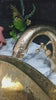 Thumbnail image of a video featuring the unlacquered brass vanity faucet in a styled bathroom, demonstrating its elegant design and golden-brass finish.