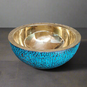 Top view of a round hammered brass basin with a shiny golden interior and turquoise patina exterior