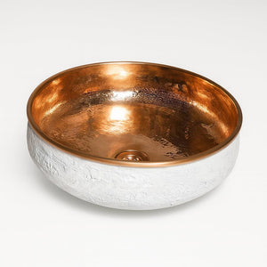 Round copper basin with hammered copper interior and textured white exterior, combining artisanal elegance with modern bathroom style