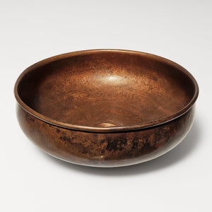 Round copper sink bowl with rich brown patina and smooth hammered finish, designed for timeless bathroom or kitchen interiors