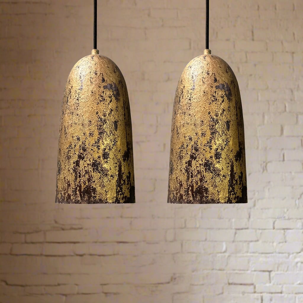 Rustic tall bell-shaped copper pendant lights with oxidized patina finish against a white brick background
