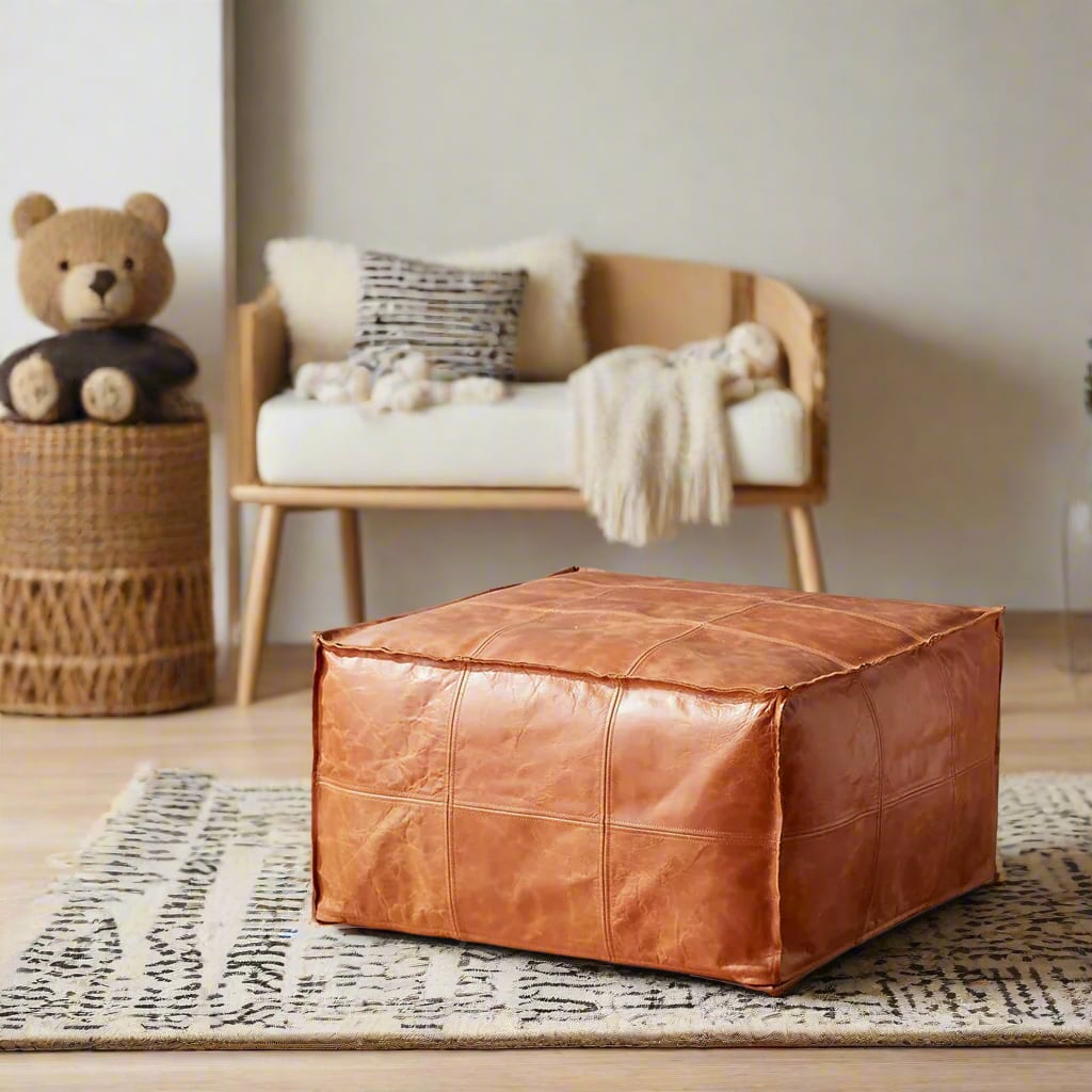 A square Moroccan leather pouf in a warm nursery setting with a soft rug, wooden furniture, and plush toys, creating a cozy and stylish space