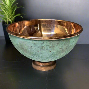 Round verdigris copper sink with glossy hammered interior displayed on a dark countertop