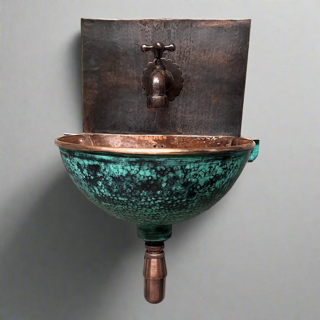 Wall-mounted verdigris copper sink with hammered finish and rustic bronze faucet, perfect for vintage-inspired and artisanal bathroom interiors