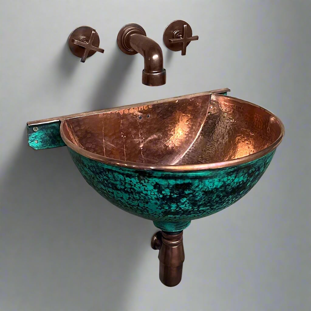 Wall-hung hammered copper sink with green patina exterior and polished copper interior, paired with matching copper faucet and cross handles