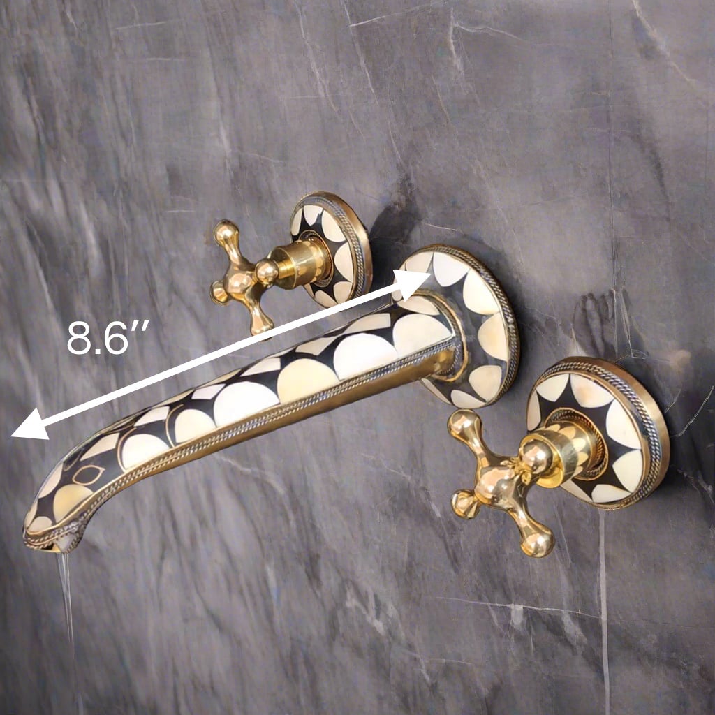 Wall-mounted faucet with an 8.6-inch spout, featuring a black and white geometric pattern and gold handles, installed on a gray tiled wall