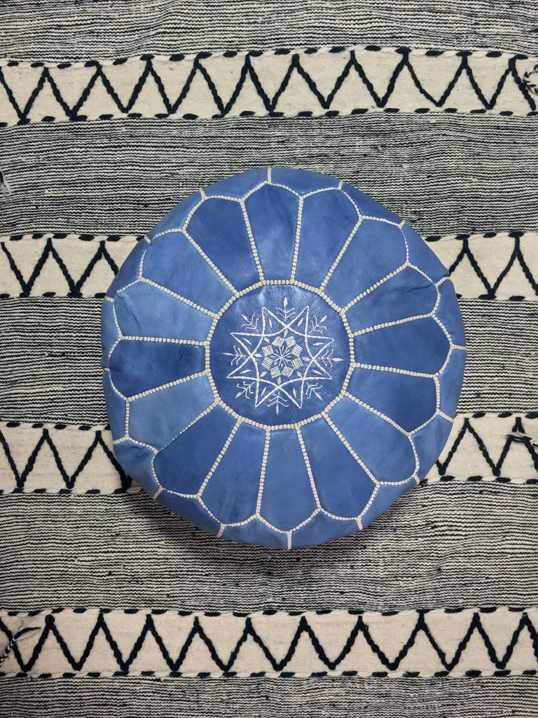 Blue jean round leather pouf on top of a berber wool rug - Moroccan Interior