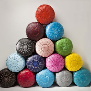 Moroccan Colorful Round Leather Pouf beside a gray wool in a room - Moroccan Interior