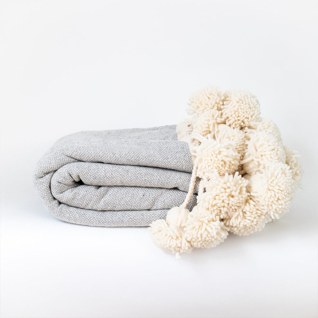 Gray Dotted Moroccan pom pom blanket against a white background - Moroccan Interior