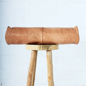 Moroccan Leather Bolster on top of a wood stool - Moroccan Interior